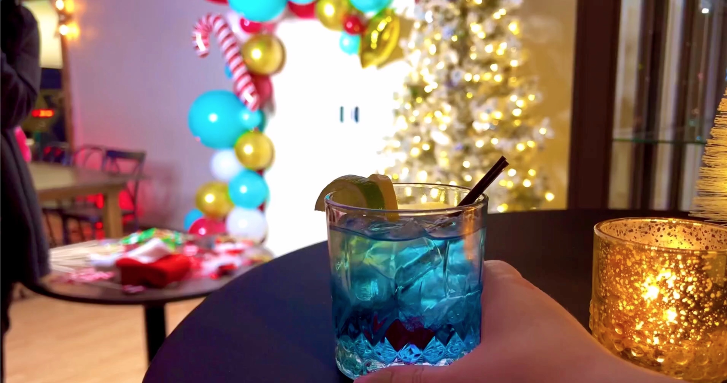 blue drink with Christmas lights and balloons in the background